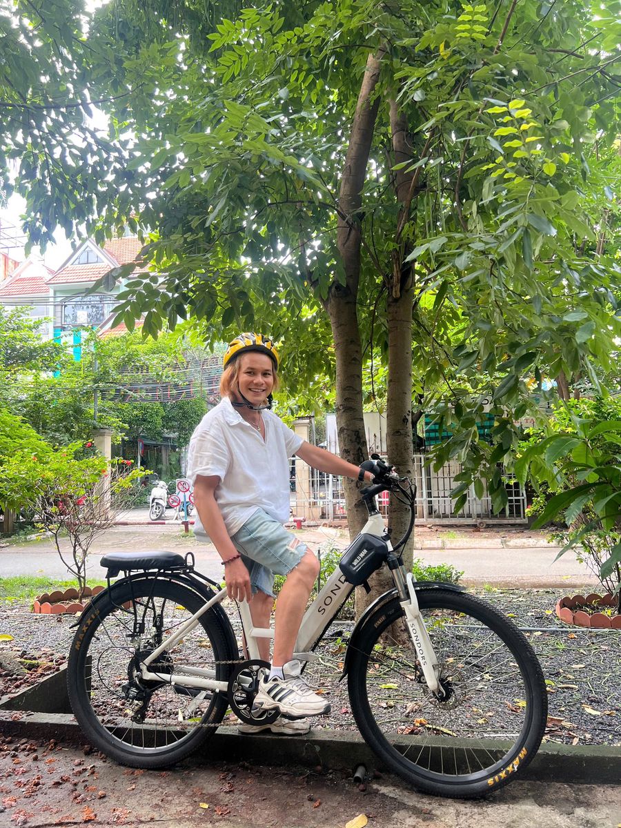 Tình Ca đạp xe dưới hàng cây